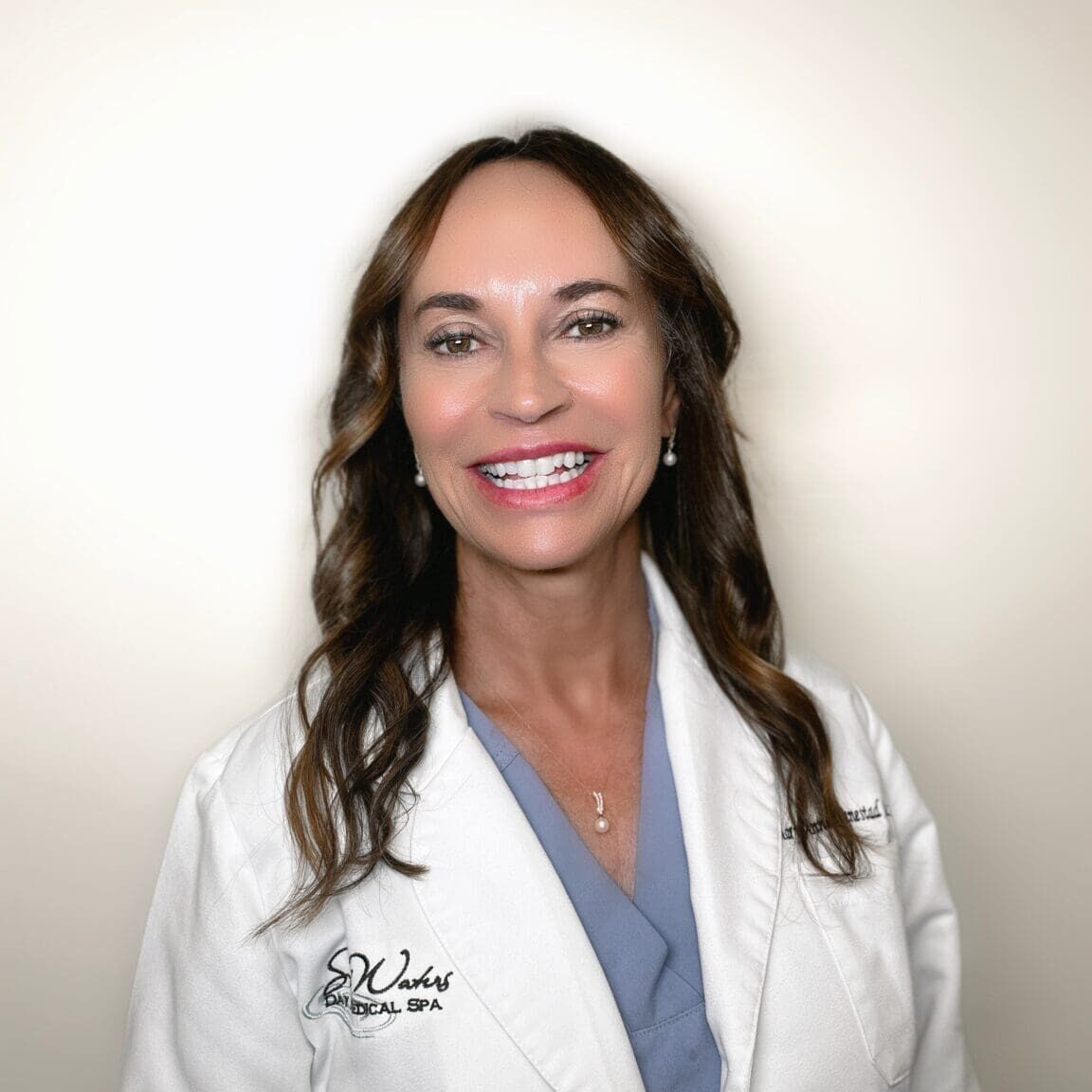 A woman in white coat smiling for the camera.